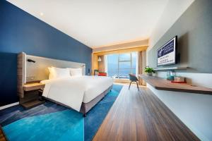 een slaapkamer met een groot wit bed en een bureau bij Holiday Inn Express Hangzhou Westlake East, an IHG Hotel in Hangzhou