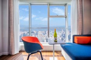 a room with a bottle of wine and a chair in front of a window at Holiday Inn Express Hangzhou Westlake East, an IHG Hotel in Hangzhou