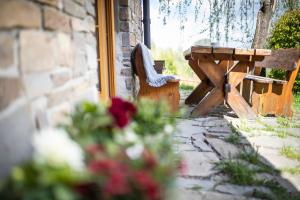 a wooden bench sitting next to a building with flowers at Willa Leluja in Zakopane
