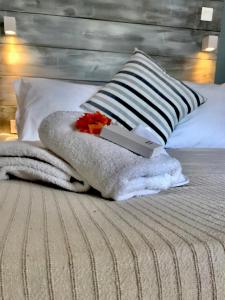 uma cama com um cobertor e um livro sobre ele em Ammos Luxury Studios em Aliki