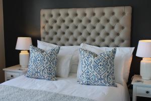 a bedroom with a large bed with blue and white pillows at Waterfront - Knysna Quays Accommodation in Knysna