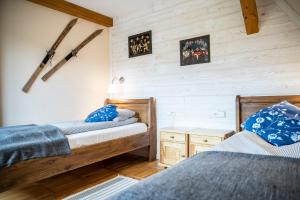 two beds in a room with wooden walls at Willa Leluja in Zakopane