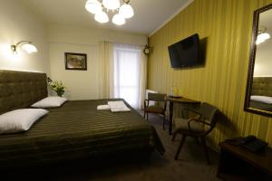a hotel room with a bed and a table and a mirror at Hotel Fryderyk in Rzeszów