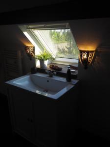 baño con lavabo y ventana en Les Remparts, en Binche