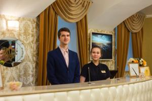 a man and a woman standing in front of a mirror at Grand Catherine Palace Hotel in Saint Petersburg