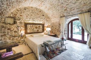 ein Schlafzimmer mit einem Bett in einer Steinmauer in der Unterkunft MarcheAmore - La Roccaccia relax, art & nature in Montefortino