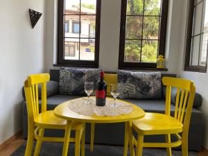 a table with two chairs and a bottle of wine at My Grandparents House in Ohrid