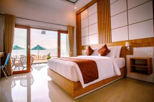 a bedroom with a bed with a view of the ocean at Samuh Sunset Nusa Penida by GenuineHost in Nusa Penida