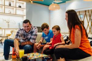 a group of people sitting on a couch at Holiday Inn Auckland Airport by IHG in Auckland
