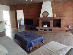 a living room with a brick fireplace and a table at Fewo Rose in Norden