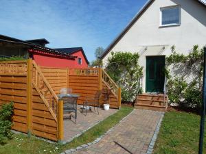 eine Terrasse mit einem Holzzaun neben einem Haus in der Unterkunft Ferien auf Rügen Familie Geist in Garz