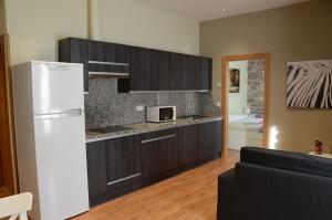 Una cocina con un refrigerador blanco y un microondas. en Apartamentos Elizondo, en Elizondo