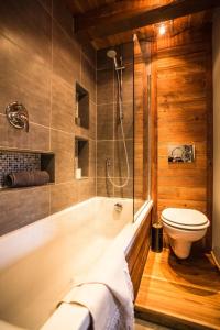 a bathroom with a white tub and a toilet at HelloChalet - Chalet D'Alpage Larose - a wild back mountain escape, large sunny garden and Matterhorn views in Valtournenche
