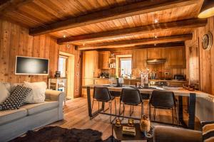 a kitchen and living room with a couch and a table at HelloChalet - Chalet D'Alpage Larose - a wild back mountain escape, large sunny garden and Matterhorn views in Valtournenche