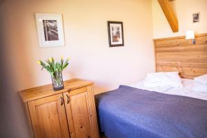a bedroom with a bed and a vase of flowers on a cabinet at Willa Leluja in Zakopane