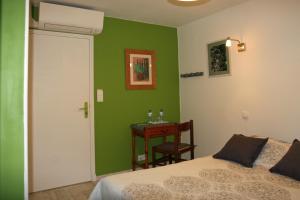 1 dormitorio con paredes verdes, 1 cama y 1 mesa en Les 3 Vallées, en Saint-Florent-le-Vieil