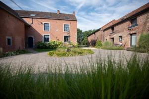 a row of brick buildings with grass in the foreground at Les gîtes du Moulin castral in Geer