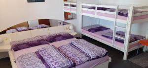 1 dormitorio con 2 literas con almohadas moradas en Pension Sport en Malá Morava