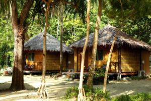 uma casa de bambu com telhado de palha e árvores em Mayalay Resort-Green Hotel em Ko Ngai