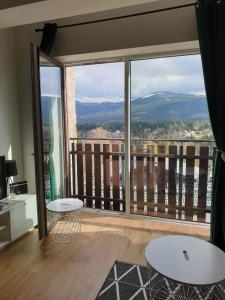a room with a balcony with a view of the mountains at Widok Karkonosze in Szklarska Poręba