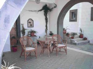 a patio with a table and chairs in a building at Apolafsis Studios in Patmos