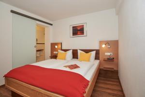 ein Schlafzimmer mit einem großen Bett mit einer roten Decke in der Unterkunft Ferienwohnungen Berganemone in Schönau am Königssee