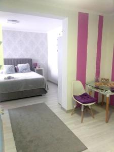 ein Schlafzimmer mit einem Bett, einem Tisch und einem Stuhl in der Unterkunft Studio AJDY in Mostar