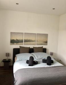 a bedroom with a large white bed with three paintings on the wall at Ferienwohnung Falkenstr. in Enger