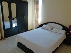 a bedroom with a black dresser and a white bed at Oceanic Villa in Grand-Baie