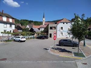 eine Straße mit Autos, die vor einer Kirche geparkt sind in der Unterkunft Gite du moulin in Gunsbach