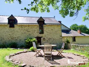 a table and chairs in front of a building at Gîte Le Logis de l'Etang de l'Aune in Iffendic