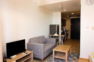 a living room with a couch and a tv at SHH - Furnished Studio in Silicon Gates 1, Silicon Oasis in Dubai