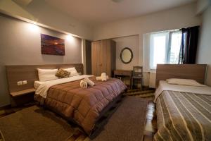 een hotelkamer met 2 bedden en een raam bij Stalaktites in Ioannina