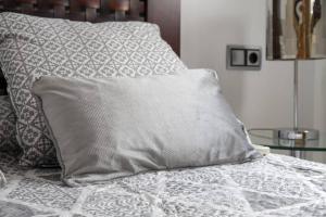 łóżko z poduszką na górze w obiekcie Penthouse Raggio w Sewilli