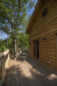 a wooden deck with a building and a tree at Le Monde de Charlie - Les Cabanes in Bellerive-sur-Allier +68 photos