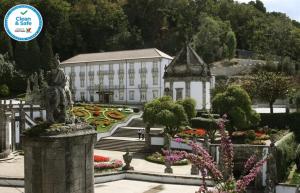 a building with a statue in front of a garden at Hotel do Templo in Braga
