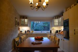 een keuken met een houten tafel en een groot raam bij CASA DO SORRO in Ponte de Lima