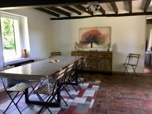 un comedor con una gran mesa de madera y sillas en Gîte à l'orée de Grandchamp, en Grandchamp