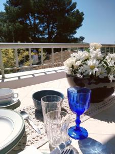 een tafel met borden en glazen en een vaas met bloemen bij Quinta dos Caracois in Lagos