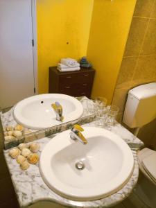 a bathroom with two sinks and a toilet at Quinta dos Caracois in Lagos