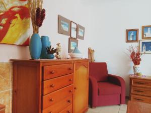 ラゴスにあるQuinta dos Caracoisのドレッサーと赤い椅子が備わる部屋