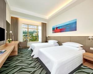 a hotel room with two beds and a television at Sunway Lagoon Hotel , formerly Sunway Clio Hotel in Kuala Lumpur