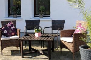 un patio con sillas de mimbre y una mesa de madera. en Ferienwohnung Bergluft, en Winterberg