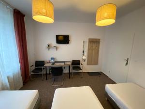 Habitación con mesa, sillas y 2 luces en Pastel Guest Rooms, en Varsovia