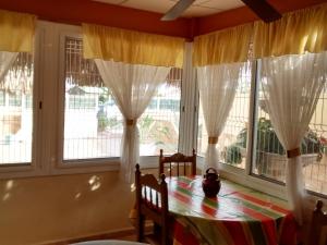 a dining room with a table and windows at Marítim family resort, Riumar 1 in Riumar