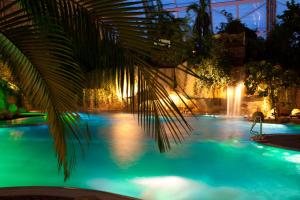 einen Pool mit einer Palme und einem Brunnen in der Unterkunft Tropical Islands in Krausnick
