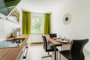 cocina y comedor con mesa y sillas en Bode_Apartments en Elend