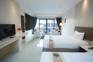 ein Hotelzimmer mit 2 Betten und einem Flachbild-TV in der Unterkunft Summer Tree Hotel in Bangna