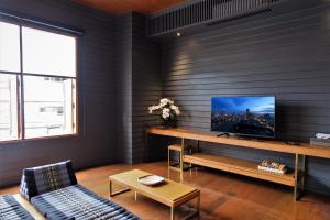 een woonkamer met een tv aan de muur bij Vali Villa Bangkok in Bangkok