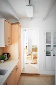 una cocina con armarios de madera y una puerta a una habitación en Siamoformentera Villa Antonella, en Sant Francesc Xavier